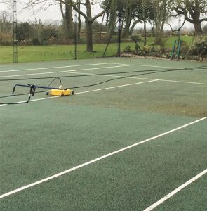 The ffects of cleaning a tarmac tennis court are clear to see.