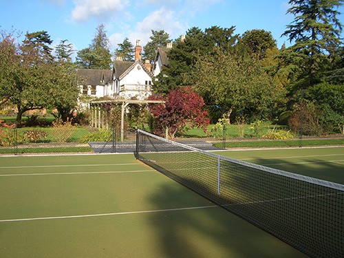 En Tout Cas tennis court with a synthetic grass surface (often called Astroturf or Fake Grass).