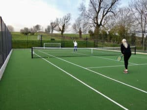 Tennis on a Savanna-surfaced MUGA. Estate fencing. En Tout Cas tennis court fencing.